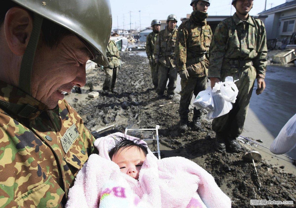 28、2011年3月14日，日本，石卷：日本自卫队的士兵从地震灾区救出一个4个月大的小女孩.jpg