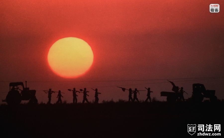1993年5月，朝鲜平安南道一处合作农场，一队农民行走在夕阳下.jpg