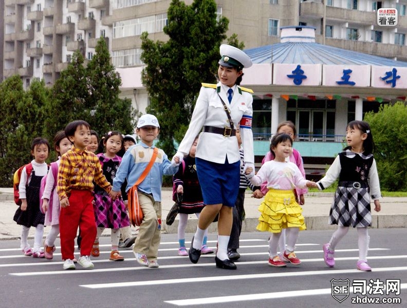 2007年5月，朝鲜平壤街头，一名女交警牵着儿童们过马路。朝中社发布的图片说明称，“幼.jpg