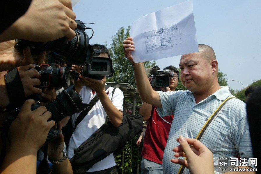 4、7月16日，廖丹走出东城法院后向媒体展示法院收据.jpg
