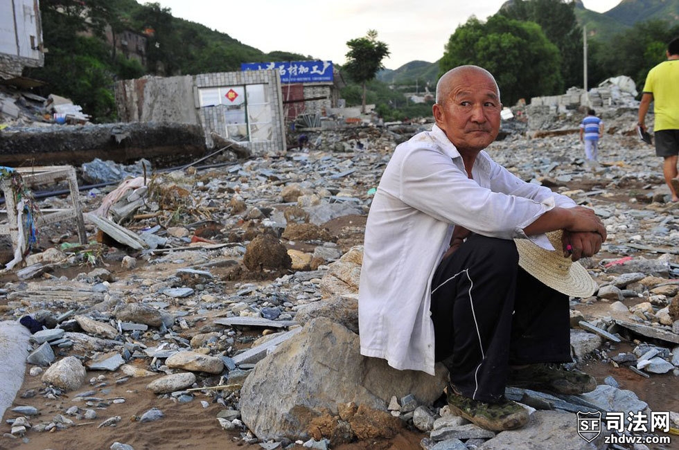 2012年7月22日，北京市房山区河北镇檀木港村，村民坐在废墟上，背后是被整体推倒的房屋.jpg