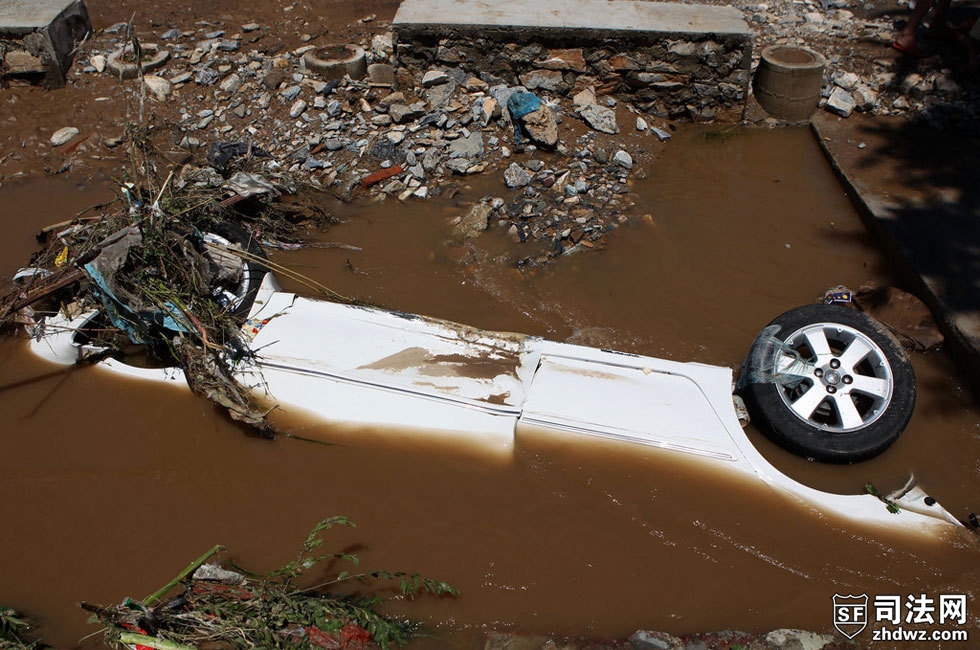 2012年7月22日中午，北京房山区北车营村，泄洪渠内躺侧躺着一台白色轿车，几乎被泥沙掩埋.jpg