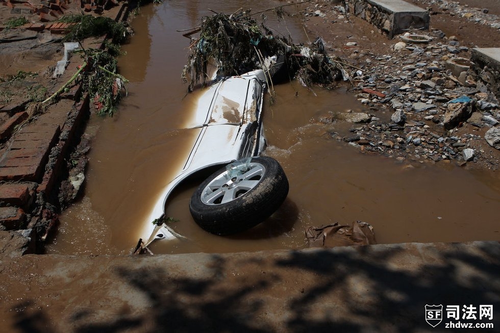 2012年7月22日中午，北京房山区北车营村泄洪渠内躺侧躺着一台白色轿车，几乎被泥沙掩埋.jpg