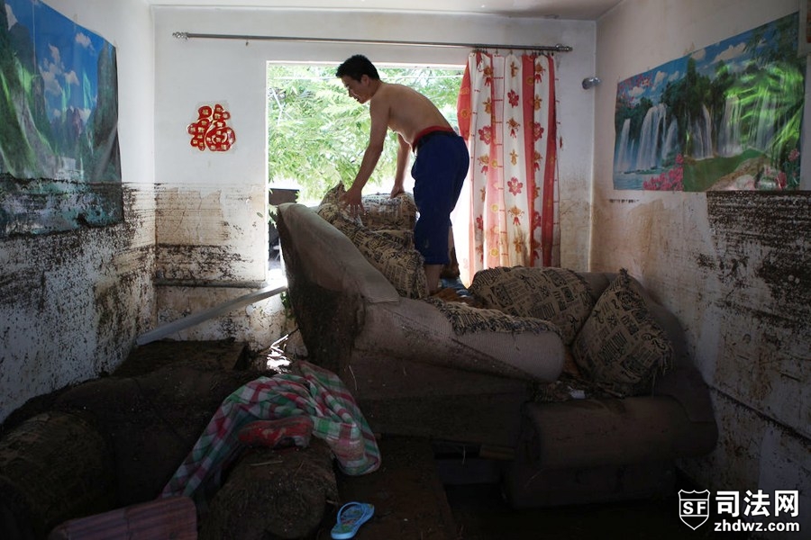 图为7月22日，北京房山，一名村民在清理家当.jpg