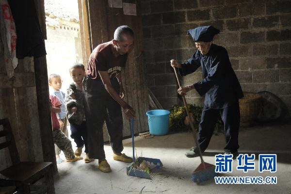 10月19日，广西河池市巴马县125岁老人罗美珍（右）和小儿子黄有才一起打扫卫生.jpg