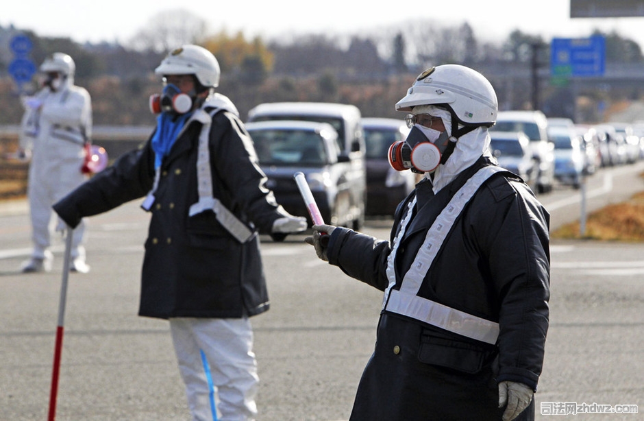 3月12日，日本福岛核电站附近，日本警方身着防护服在进行撤离疏导.jpg