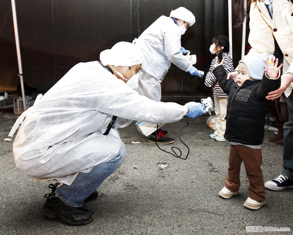 3月13日，日本福岛郡山市，工作人员正在检测一名从福岛核电站附近撤离儿童身上的辐射情况.jpg