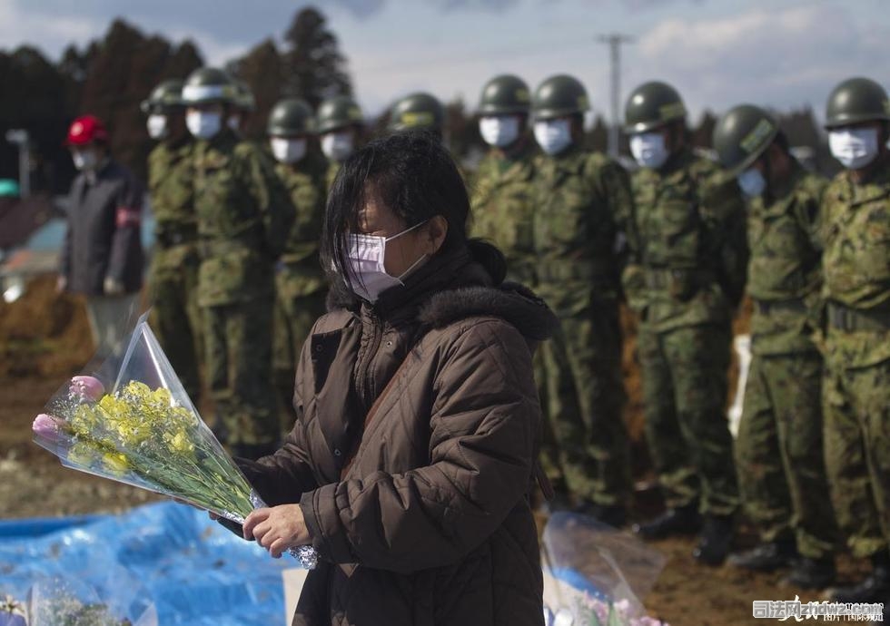 6、当地时间2011年3月26日，日本：工作人员把地震和海啸中遇难人员尸体进行集体掩埋.jpg