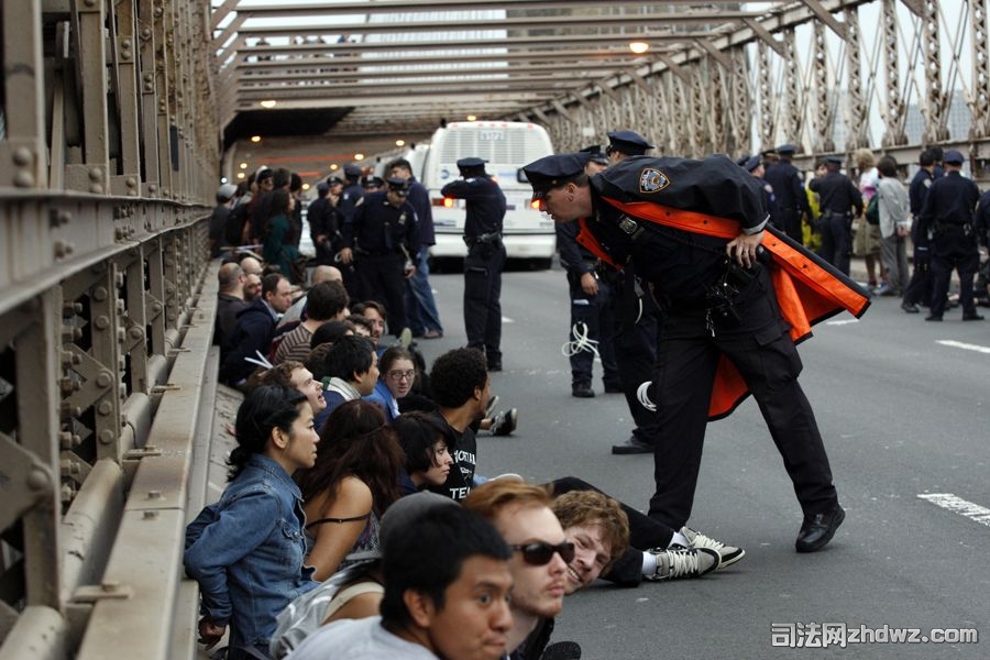 当地时间10月1日，美国纽约布鲁克林大桥上，一名警察与被捕的抗议示威者交谈.jpg