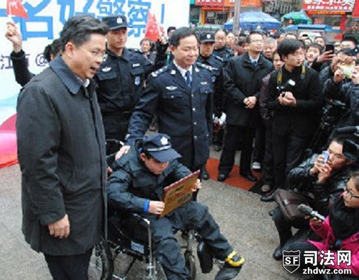 图为制服“劫匪”后，现场围观的数千市民纷纷鼓掌。新余市市长为小骏億颁发“见义勇为小警察”荣誉奖牌。