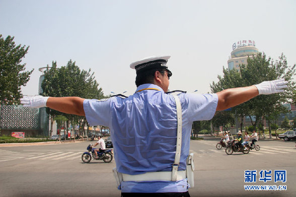 7月6日，山东日照一名交警顶着高温在市区路口指挥交通.jpg