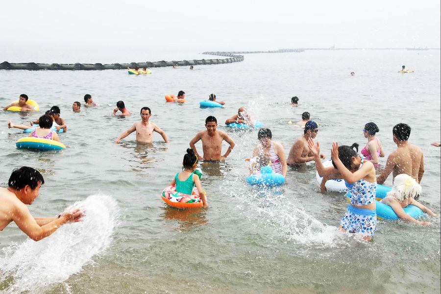 7月24日，大连付家庄海滨浴场，游客在隔油带旁消暑纳凉-1.jpg