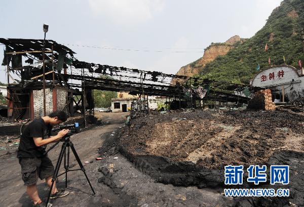 7月31日，一名记者在发生爆炸事故的刘沟煤业公司拍摄.jpg