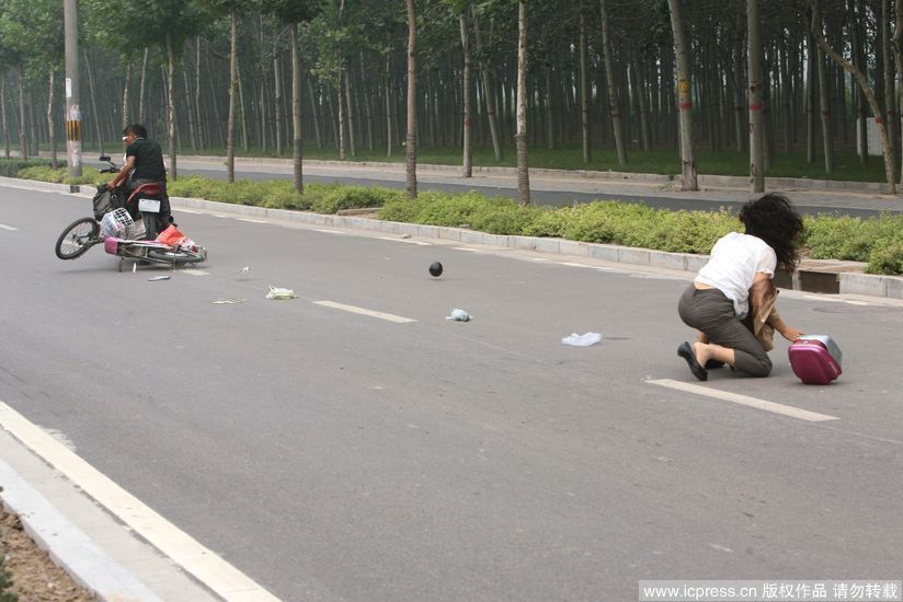 女子被拖倒后，电动车被“飞车党”拖行.jpg